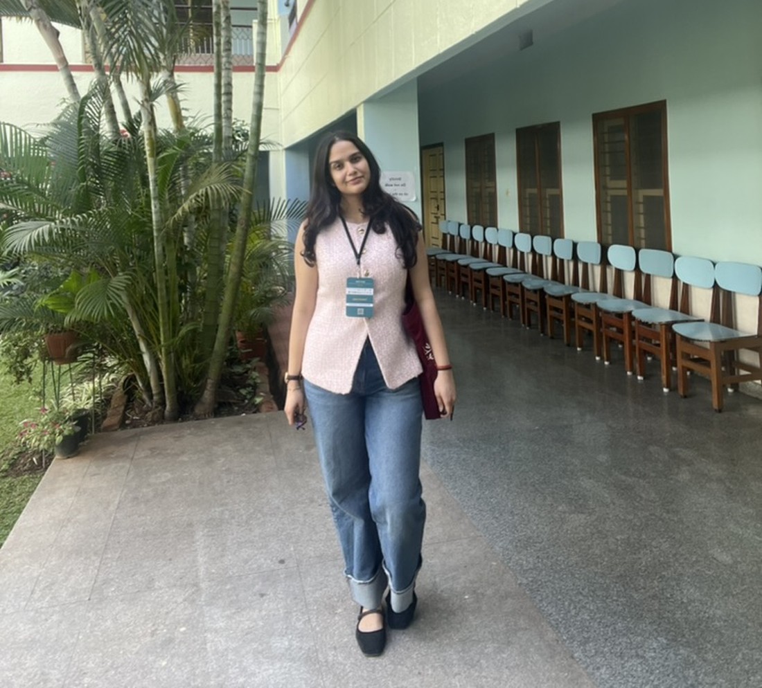 Tushti Hari standing in a college corridor, wearing a lanyard.
